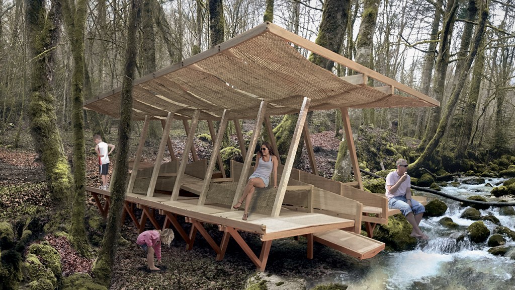 A stylish wooden structure with a thatched roof located in a forested area beside a flowing stream, with several people enjoying the serene environment.